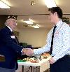 Commander Alan Roach congratulates Michael Tan on being selected as first place in the local VFW Voice of Democracy essay competition at an awards luncheon in Sandpoint.