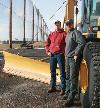Mike and Rich Peplinski stand next to their newest loader fitted with a snow blade and snow wing. The father-and-son team has contracted to plow snow for the city since it was incorporated in 2001.